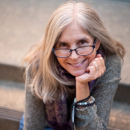 Portrait of Michelle Polgar, a white woman with glasses and a friendly smile, looking at the camera.