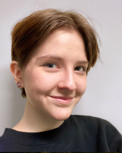 Portrait of Rosie Grunzke, a white college student with short brown hair, wearing a a black t-shirt.