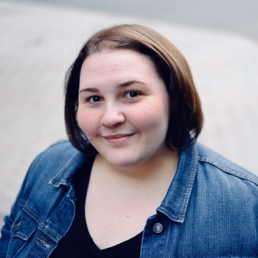 Portrait of a smiling woman with short dark hair, wearing a jean jacket