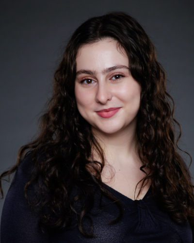 Portrait of Cipa Frost, a young white woman with long dark flowing hair, pale skin, and red lipstick.