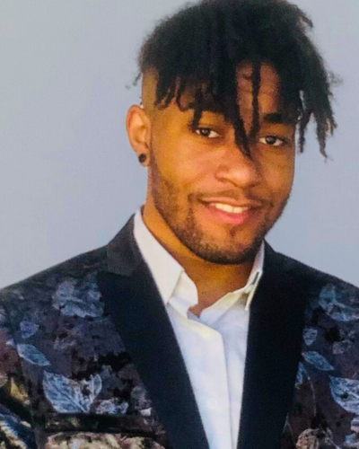 Portrait of Frederick Windross, a black graduate student with closely trimmed facial hair, wearning a blue brocade dinner jacket.