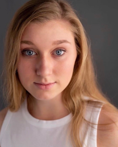 Portrait of Gianna Nichols, a white college student with long straight blond hair, wearing a white tank top