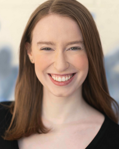 Portrait of Julia Smith, a white college student with long, straight auburn haor and a big smile