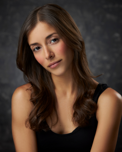 Portrait of Marieangelie Velez, an hispanic graduate student with long dark hair and big brawn eyes, wearing a black tank top