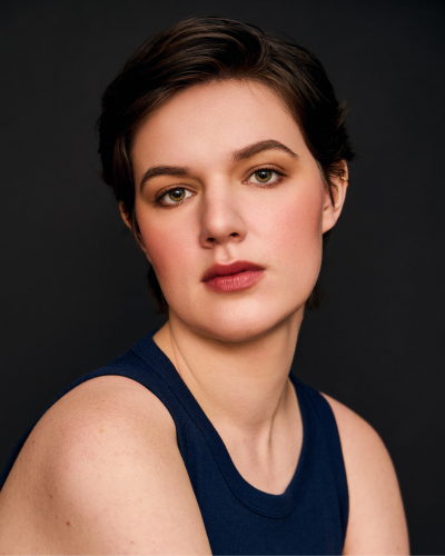 Portrait of an undergraduate student with dark hair, pulled back, wearing a black talk top