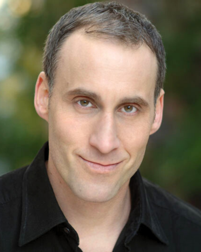 Portrait of a smiling white man wearing a dark polo shirt.