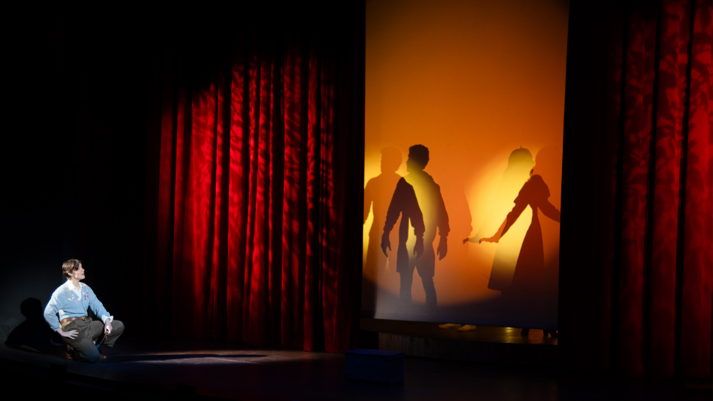 Jaques introduces the play, as shadow versions of Rosalind and Orlando appear behind her.