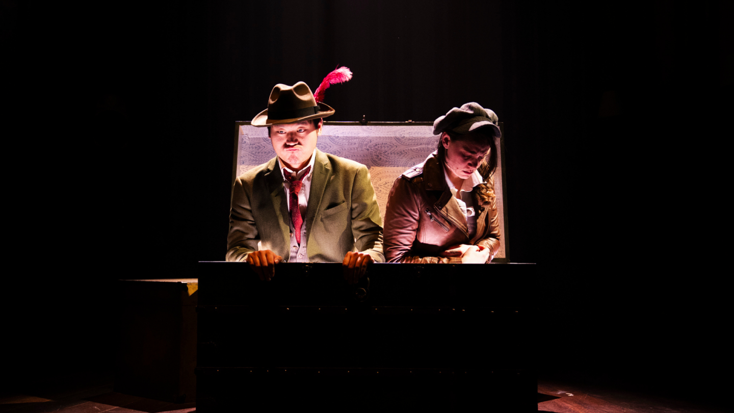 Peter and Wendy sit in the large trunk