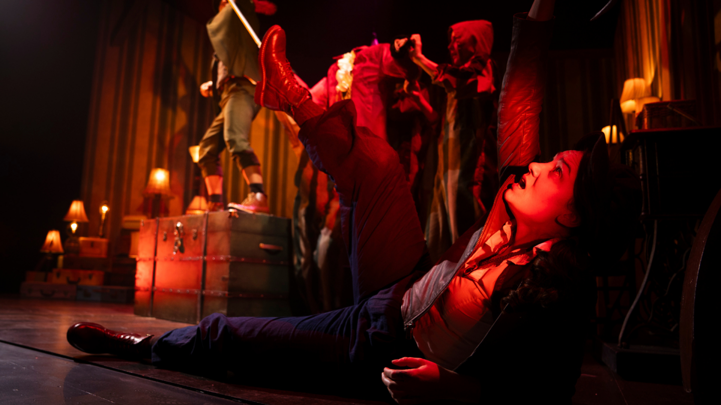 Bathed in red light, the puppet form of Captain Hook hovers above a fallen Wendy.